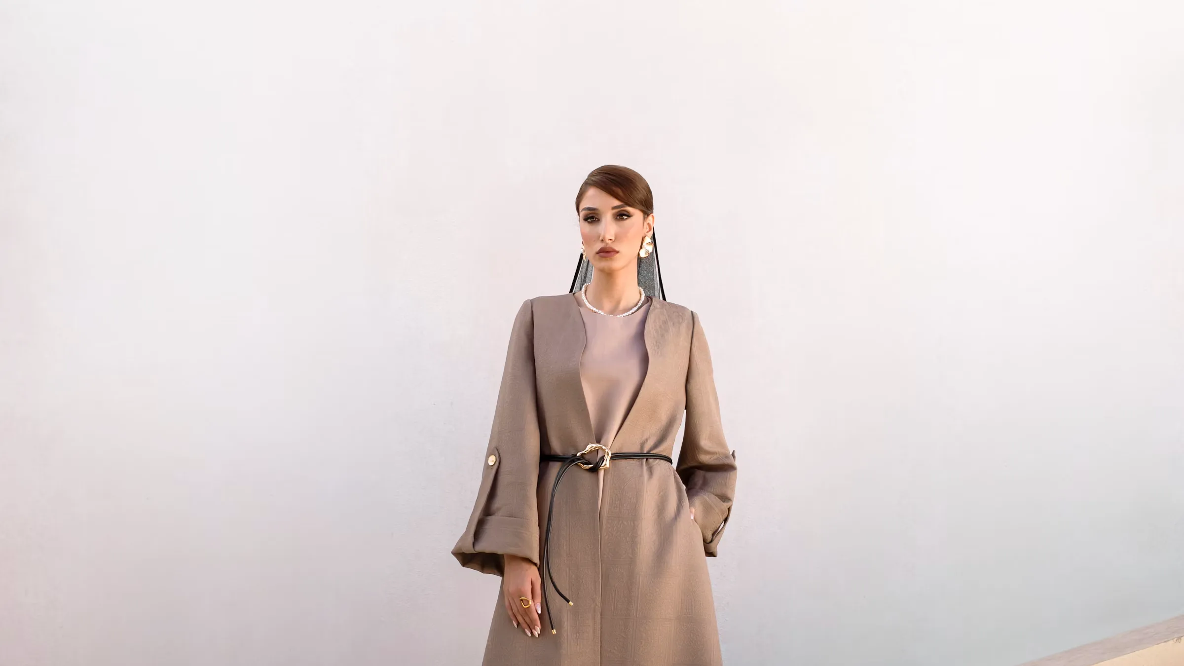Halden concept: a model in a long camel coat on pale stairs